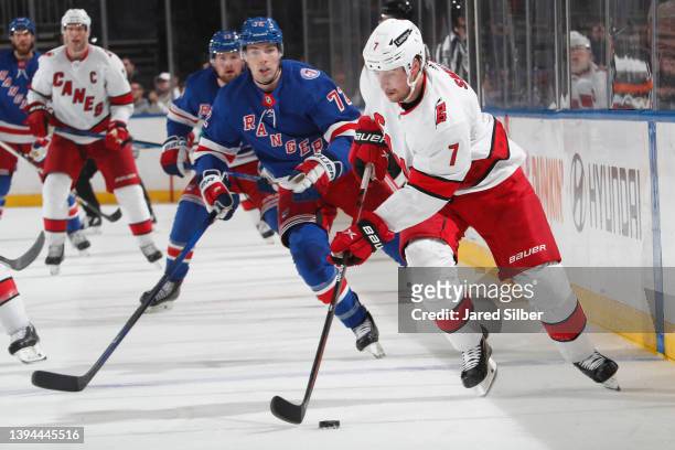 Brendan Smith of the Carolina Hurricanes skates with the puck against Filip Chytil of the New York Rangers at Madison Square Garden on April 26, 2022...