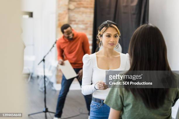 young woman listens as unrecognizable female friend recites lines - acting stock pictures, royalty-free photos & images