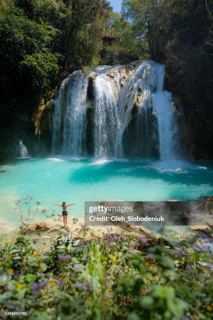 Woman raising arms near El Chiflon waterfall in Chiapas