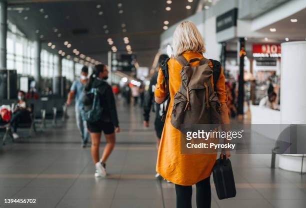 solo-reisender auf dem weg zum flugtor - orange dress stock-fotos und bilder