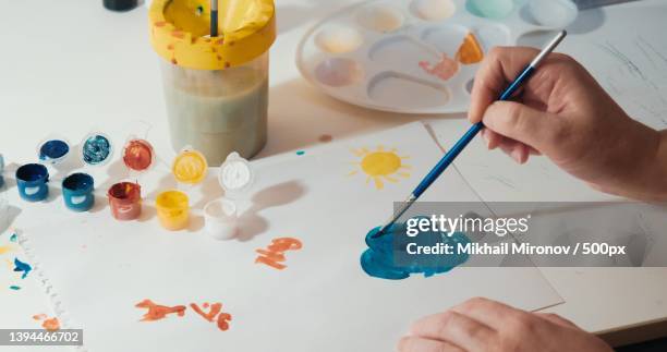 aged woman paints on paper the concept of hobbies,relaxation hands - art therapy stock pictures, royalty-free photos & images