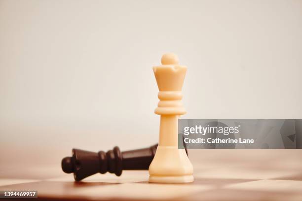 chess game with two queen chess pieces. focus on single game piece. concept of strategy and competition - queen chess piece stock-fotos und bilder