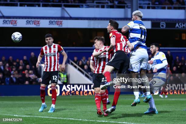 Charlie Austin of Queens Park Rangers scores their team's first goal under pressure from Chris Basham of Sheffield United during the Sky Bet...