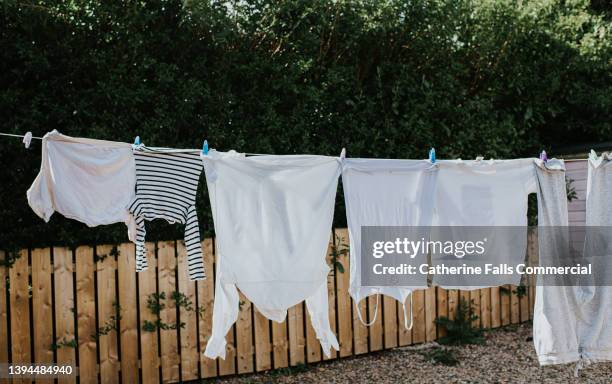 a row of white washing hangs on a washing line, drying in the sun. - recycled coffee cup sculpture highlights affects of everyday waste stockfoto's en -beelden