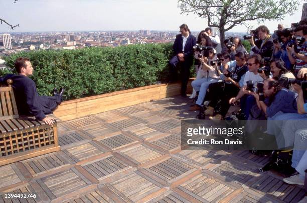 American actor Luke Perry , poses for photographers while sitting on a rooftop circa 1995.