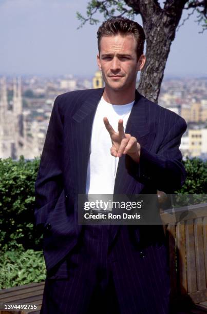 American actor Luke Perry , poses for photographers while sitting on a rooftop circa 1995.