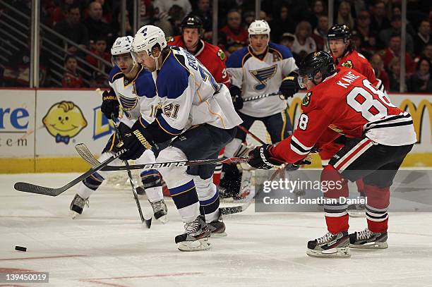 Patrik Berglund of the St. Louis Blues chases the puck under pressure from Patrick Kane of the Chicago Blackhawks at the United Center on February...