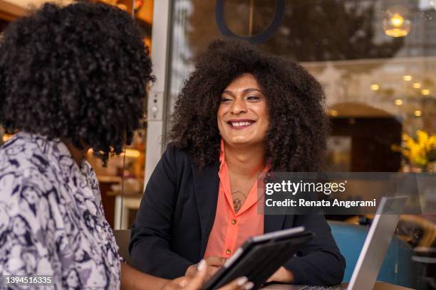 transgender woman and her business partner working at cafe - hbtq personer bildbanksfoton och bilder