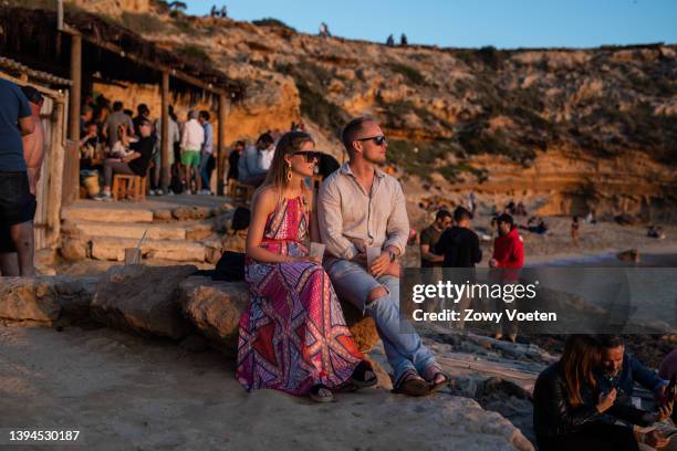 Dutch tourists enjoy the sunset in Escondida beach on April 29, 2022 in Ibiza, Spain. The Spanish Mediterranean island of Ibiza, summer outpost for...