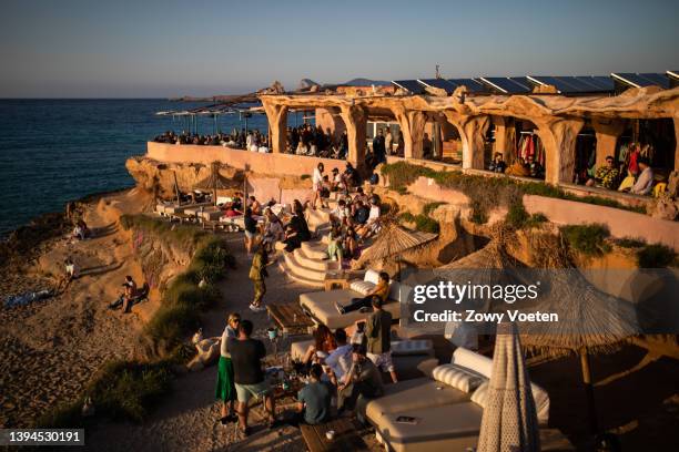 Tourists enjoy the sunset at the Sunset Ashram beach bar in Cala Comte on April 29, 2022 in Ibiza, Spain. The Spanish Mediterranean island of Ibiza,...