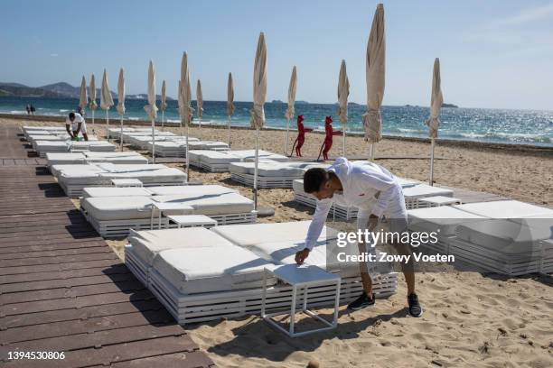 Toti, waiter at the bech club of the Ushuaia prepares the sunbeds on the beach for the customers on April 29, 2022 in Ibiza, Spain. The Spanish...