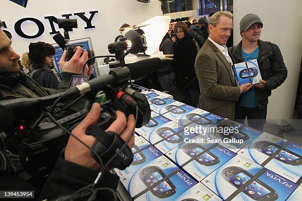 Uwe Bassendowski , head of Sony Computer Entertainment Deutschland, poses with Ingo, who was the first to buy the new Sony PlayStation Vita portable...