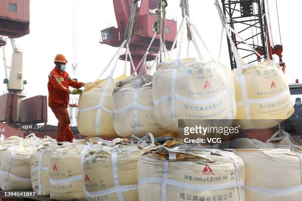 Docker helps transfer sacks of sodium carbonate at Lianyungang Port during the May Day holiday on April 30, 2022 in Lianyungang, Jiangsu Province of...