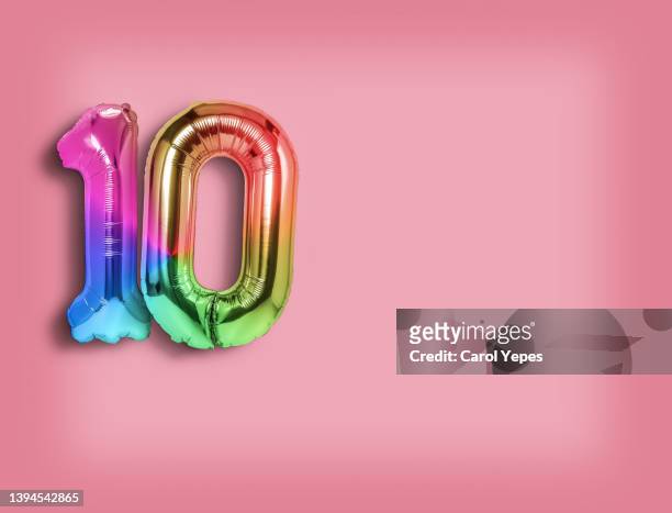 number ten foiled balloon in  rainbow colors against pink surface copy space - 2nd anniversary fotografías e imágenes de stock