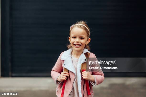 closeup of beautiful school girl standing outside - alleen één meisje stockfoto's en -beelden