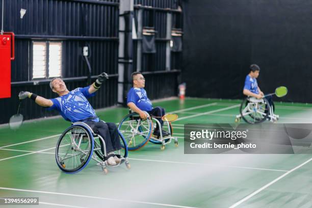 handicapped badminton players actively training their skills - polio stockfoto's en -beelden