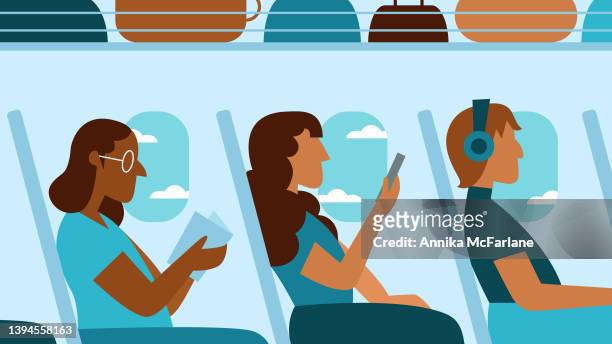 drei multirassische passagierinnen genießen den flugzeugflug, während sie lesen und das smartphone benutzen - flugzeugsitz stock-grafiken, -clipart, -cartoons und -symbole