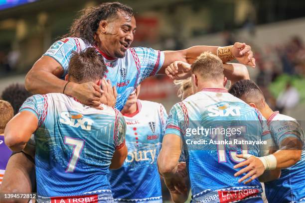 Rebels players celebrate after Reece Hodge of the Rebels scores a try during the round 11 Super Rugby Pacific match between the Melbourne Rebels and...
