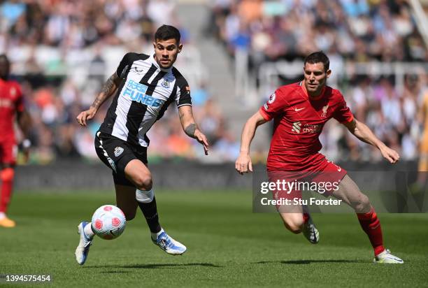 Bruno Guimaraes of Newcastle United is challenged by James Milner of Liverpool during the Premier League match between Newcastle United and Liverpool...