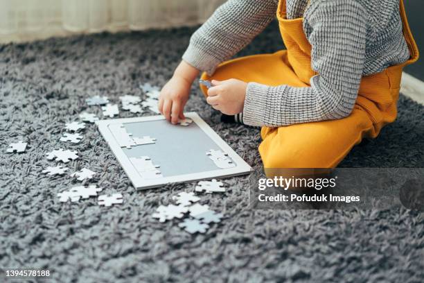 cute boy doing puzzle on carpet - puzzle 4 puzzle pieces stock pictures, royalty-free photos & images