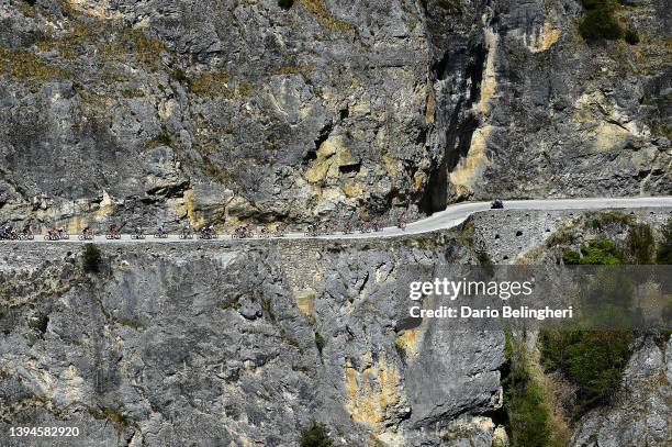 Rohan Dennis of Australia and Team Jumbo - Visma Turquoise Leader Jersey and a general view of the peloton passing through a rocky landscape at Les...