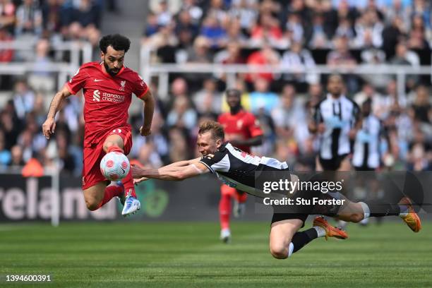 Dan Burn of Newcastle United tackles Mohamed Salah of Liverpool during the Premier League match between Newcastle United and Liverpool at St. James...