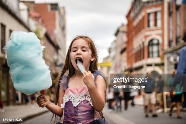 little girl eating a cotton candy - cotton candy stock pictures, royalty-free photos & images