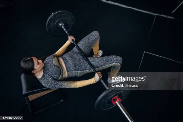 young woman training with weights - women's weightlifting stock pictures, royalty-free photos & images