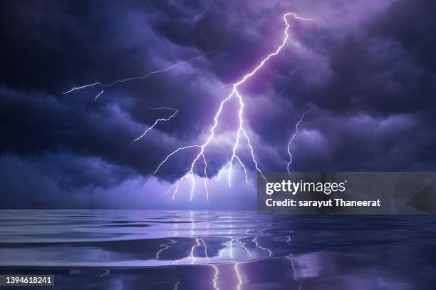 lightning monsoons into the ocean seas with harsh weather conditions. - thunderstorm ocean blue stock-fotos und bilder