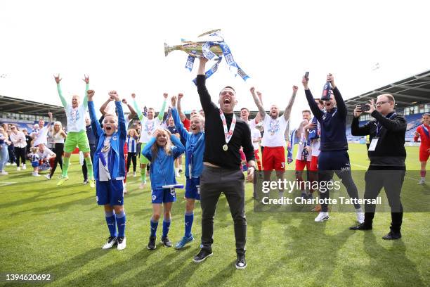 Leam Richardson, Manager of Wigan Athletic celebrates with the League One trophy after their sides victory and promotion to the Championship during...