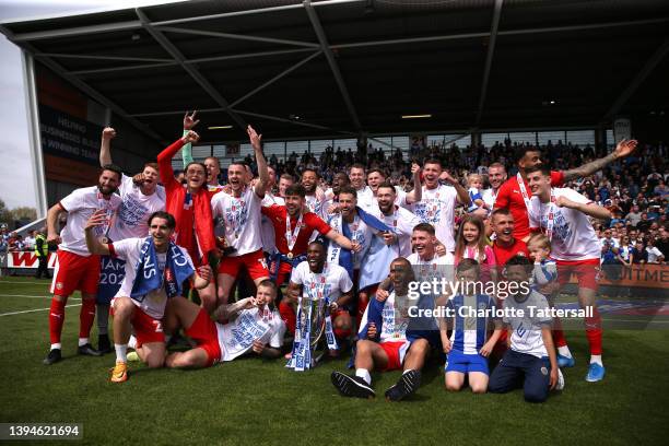 Wigan Athletic players celebrate with the League One trophy after their sides victory and promotion to the Championship during the Sky Bet League One...