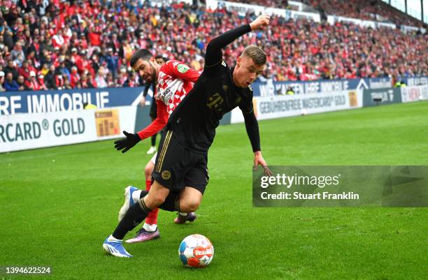 Gabriel Vidovic of FC Bayern Muenchen is tackled by Aaron Martin of 1.FSV Mainz 05 during the Bundesliga match between 1. FSV Mainz 05 and FC Bayern...