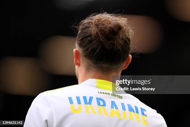 Luke Ayling of Leeds United warms up wearing a t-shirt to indicate peace and sympathy with Ukraine prior to the Premier League match between Leeds...