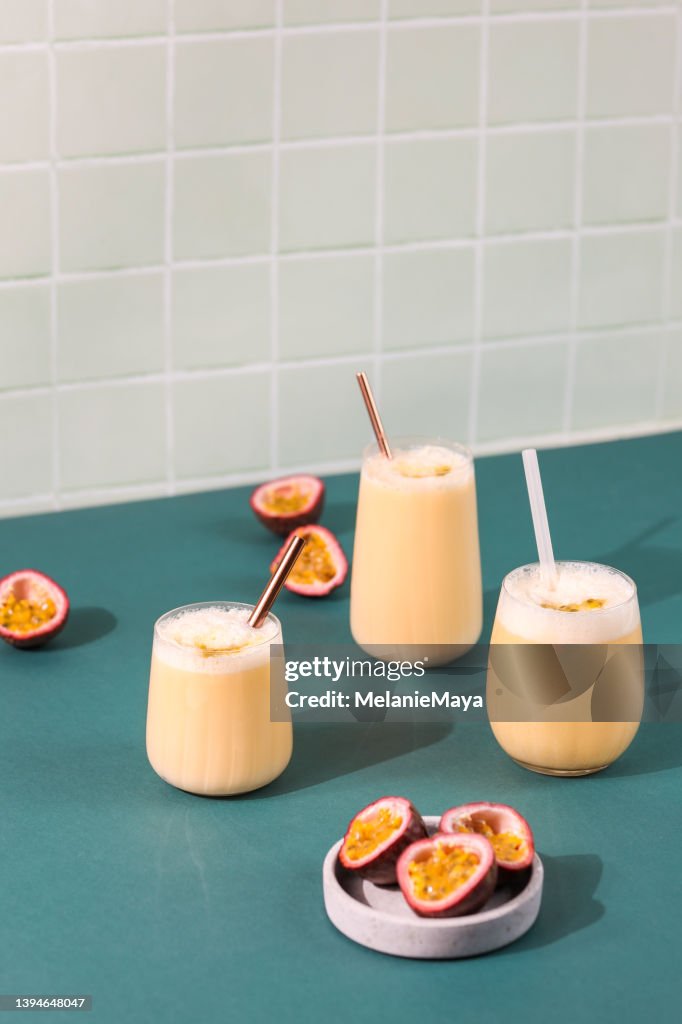 Passion fruit drink cocktail milkshake in retro bar with fresh fruit and palm leaf