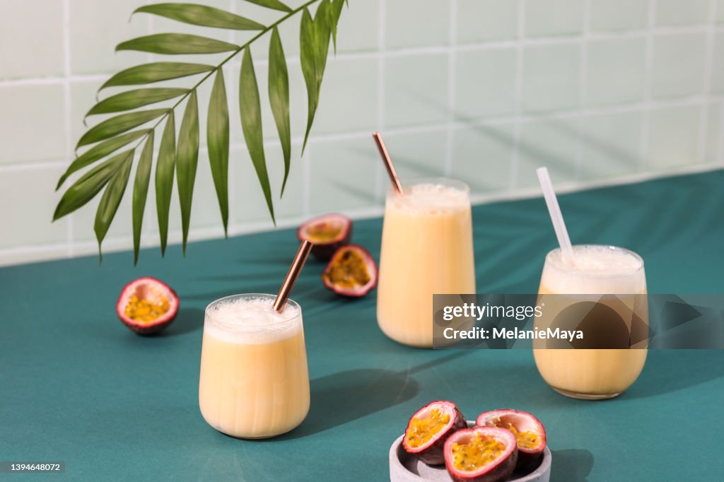 Passion fruit drink cocktail milkshake in retro bar with fresh fruit and palm leaf