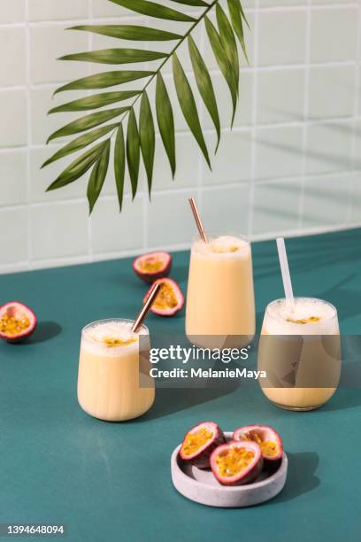 passion fruit drink cocktail milkshake in retro bar with fresh fruit and palm leaf - passion fruit stock pictures, royalty-free photos & images