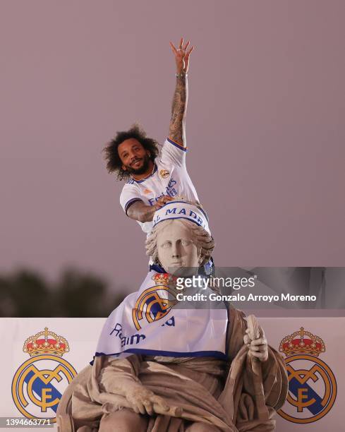 Marcelo of Real Madrid celebrates on top of the fountain at Plaza de Cibeles following their victory in their LaLiga match against RCD Espanyol which...