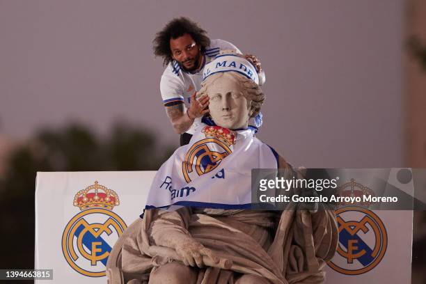 Marcelo of Real Madrid celebrates on top of the fountain at Plaza de Cibeles following their victory in their LaLiga match against RCD Espanyol which...