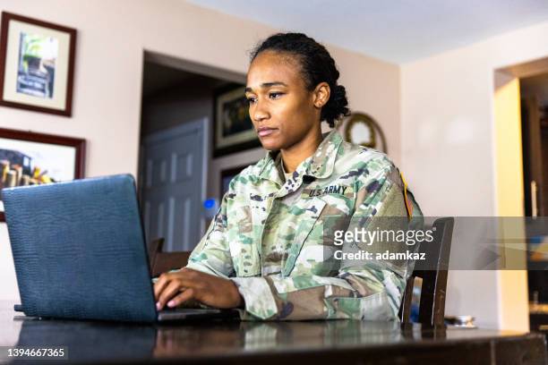 jovem membro do serviço militar negro dos eua usando laptop em casa - exército americano - fotografias e filmes do acervo