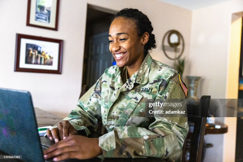 Jeune militaire noir de l’armée américaine utilisant un ordinateur portable à la maison