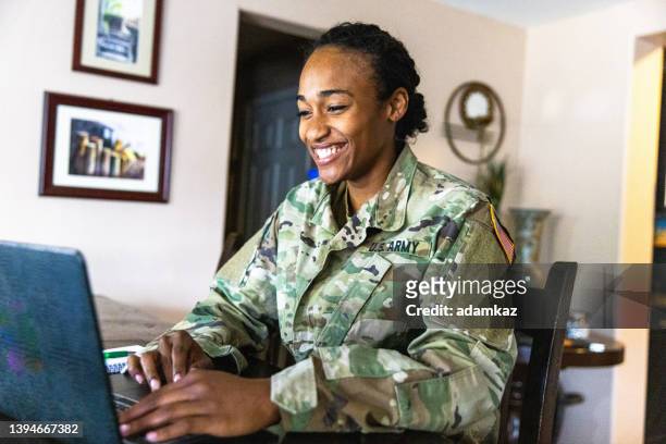 jovem membro do serviço militar negro dos eua usando laptop em casa - milícia - fotografias e filmes do acervo
