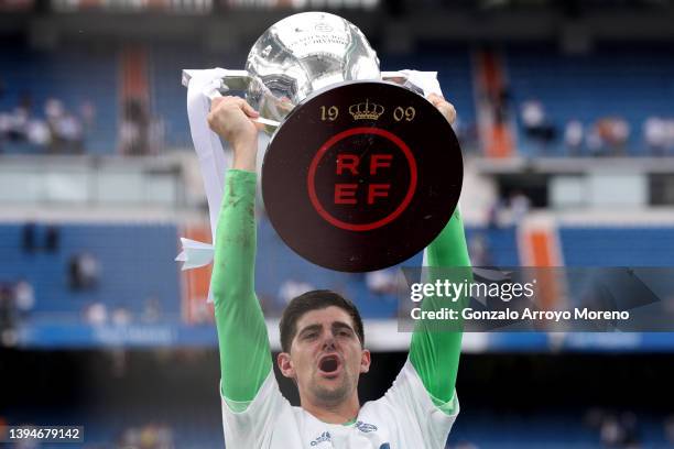 Goalkeeper Thibaut Courtois of Real Madrid CF rises the La Liga trophy as he celebrates following their side's victory in the LaLiga Santander match...