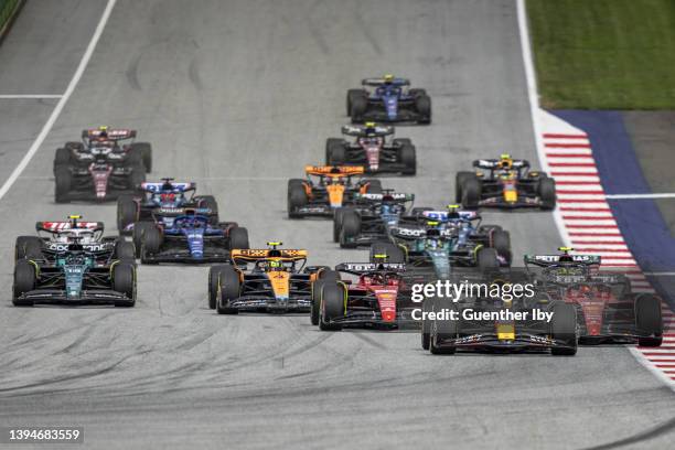 Max Verstappen of Netherlands and Red Bull leads the race in the first corner before Charles Leclerc of Monaco and Ferrari and Carlos Sainz of Spain...