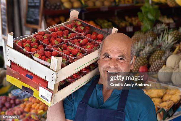 grocer carrying a box of strawberries - market vendor 個照片及圖片檔