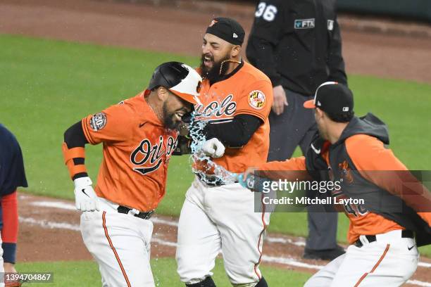 Robinson Chirinos of the Baltimore Orioles is sprayed with water after Chirinos' bunt scored the winning run in the tenth inning during a baseball...