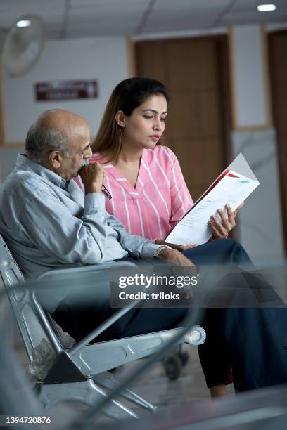 daughter analyzing test results of old father in hospital - medical test results stock pictures, royalty-free photos & images