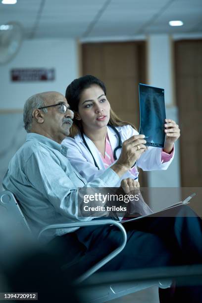female doctor discussing over x-ray with patient in hospital - medical test results stock pictures, royalty-free photos & images