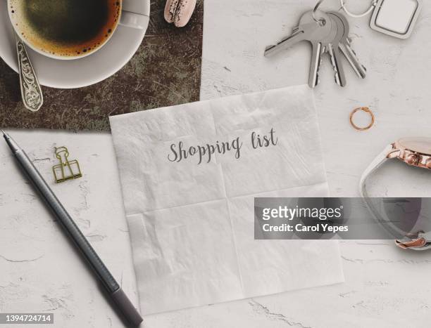 shopping list written in paper napkin with  pen, coffee and keys around.top view - paper napkin stock pictures, royalty-free photos & images