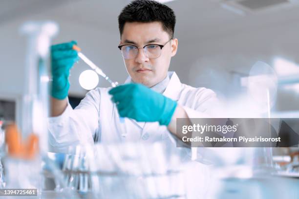 portrait of young asian man scientist working in laboratory. doctor and scientist work in laboratory pandemic of corona virus, covid19 concept - department of health and human services stock pictures, royalty-free photos & images