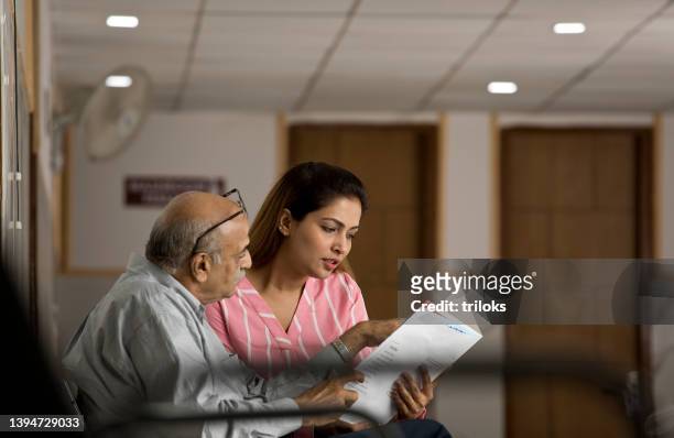 daughter analyzing test results of old father in hospital - family hospital old stock pictures, royalty-free photos & images